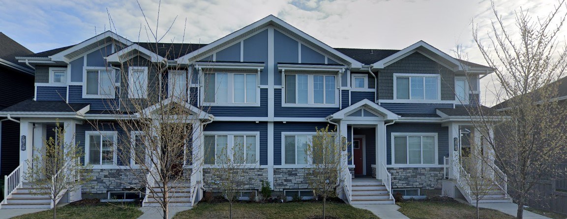 A blue two-story house with a front porch.